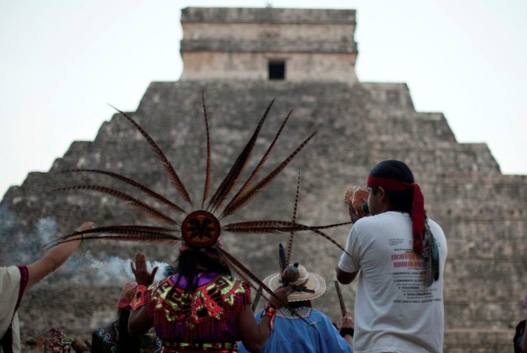 FILE PHOTO: A group of people wearing pre-Hispanic costumes perform a ritual near the pyramid of Kukulkan at the archaeological zone of Chichen Itza in Yucatan State, December 21, 2012. REUTERS